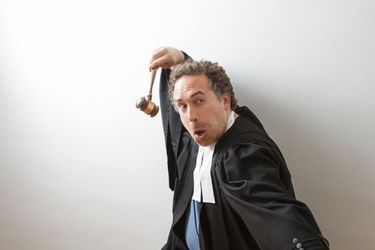 Man in canadian laywer robe with a gavel in hand in fake kung fu fighting form