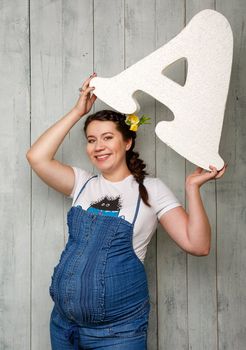 Beautiful pregnant girl on a large stage of pregnancy photographed in the studio