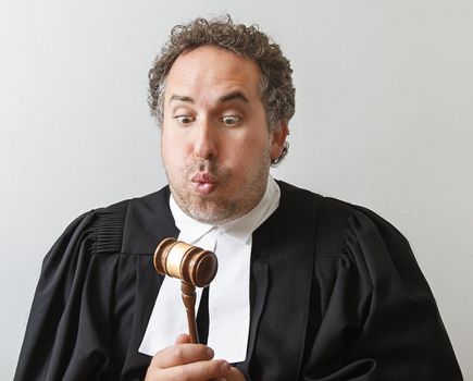 Man in canadian laywer robe slamming blowing on a gavel