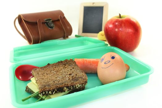 a lunch box with a busy slice of bread and a carrot and an apple