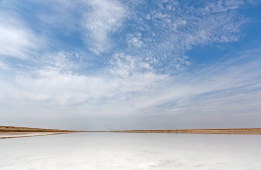 Views of  desert landscape and  salty lake on  background of blue sky, Russia.