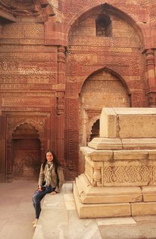 Young woman sitting inside Qutub Minar complex, Delhi, India