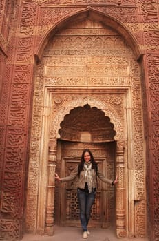 Young woman standing inside Qutub Minar complex, Delhi, India