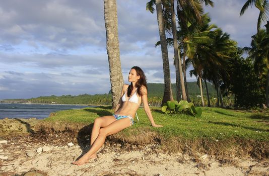 Young woman in bikini sitting at Las Galeras beach, Samana peninsula, Dominican Republic