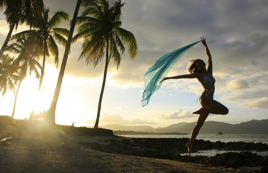 Silhouette of young woman jumping at Las Galeras beach, Samana peninsula, Dominican Republic