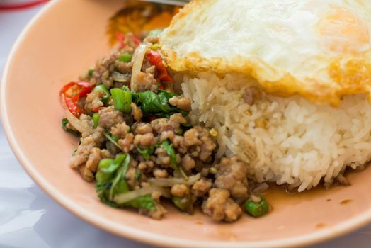 Stir basil and fried egg is a popular food in Thailand.