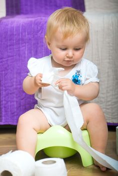 adorable baby on the potty with toilet paper