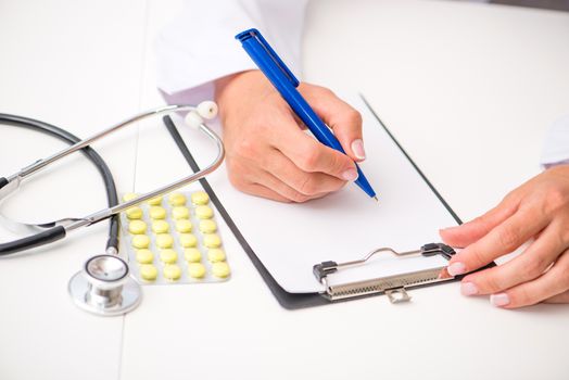 doctor's hands with a plane-table, pen and stethoscope