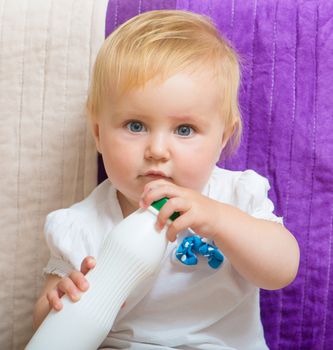 baby with white bottle in hands