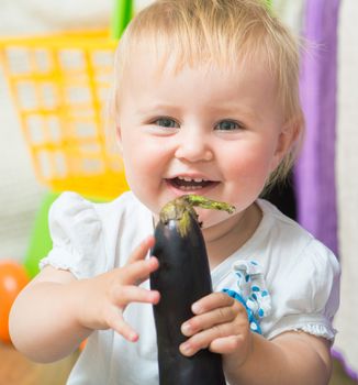 portrait of adorable baby with eggplant