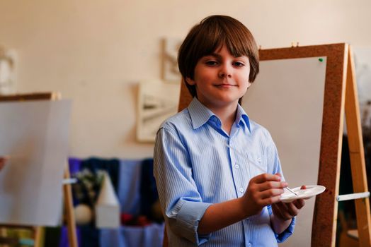 portrait of a boy standing next to his easel, a drawing lesson