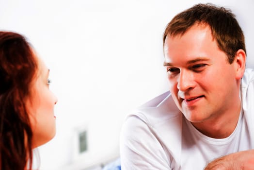 young man lying in bed with his girlfriend, spend time together at home