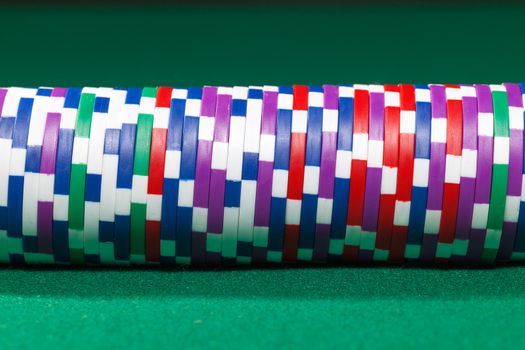 Colorful poker chips closeup on green cloth