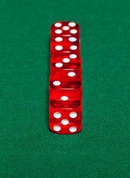 Red dice on green background, closeup