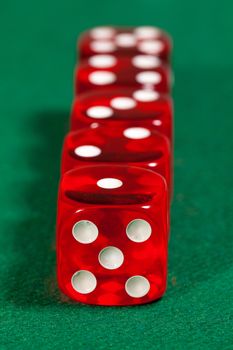 Red dice on green background, closeup