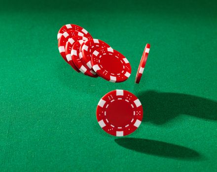 Red poker chips closeup on green cloth