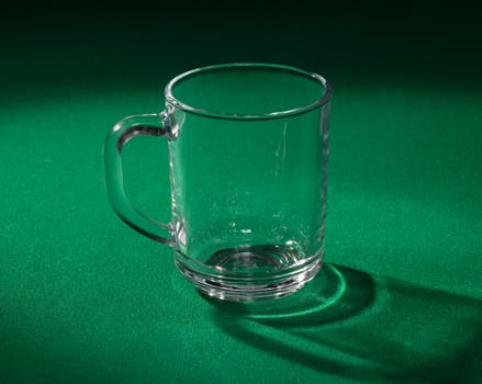 Empty glass beaker on green background