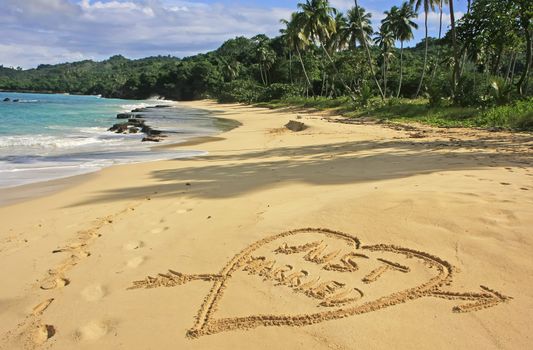 "Just married" written in sand on a beach