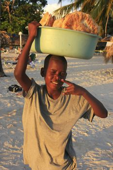 Local boy selling bread at Boca Chica beach, Dominican Republic