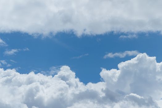Fluffy clouds in a bright Summer blue sky.