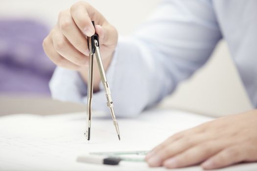 Hands of engineer working with compasses