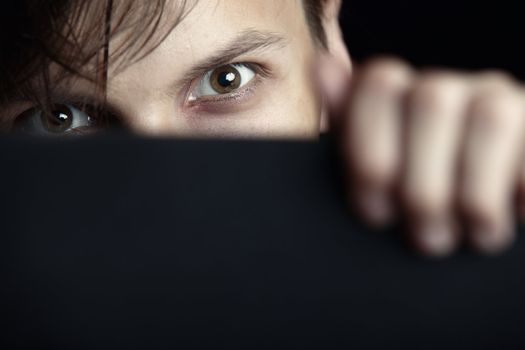 Evil man hides behind the black board and observes