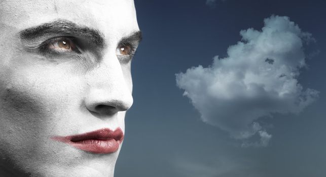 Headshot of the vampyre outdoors and cloud on the background. Artistic colors and darkness added