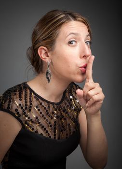 Attractive caucasion girl wearing an evening gown in her 30s shot in studio isolated on a grey background