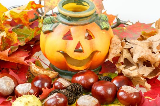 Halloween Pumpkin Lantern with chestnuts cones and autumn leaves