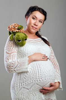 Attractive pregnant girl in a beautiful dress, shot in the studio