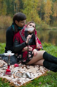 relationship between man and a woman at a picnic with a hookah