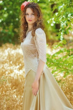 Portrait of a beautiful young woman with curly hair in a smart suit on nature