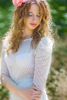 Portrait of a beautiful young woman with curly hair in a smart suit on nature