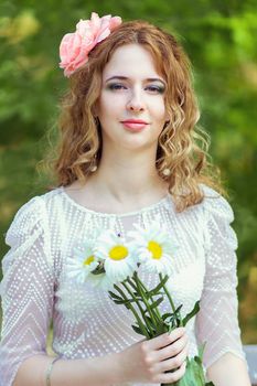 Portrait of a beautiful young woman with curly hair in a smart suit on nature