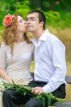 Portrait of a beautiful young woman with curly hair in a smart suit on nature and man