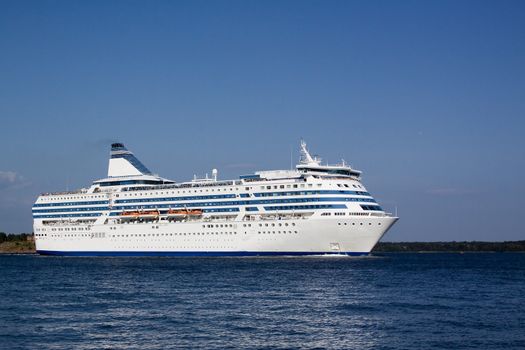 
the passenger cruise liner floats by sea by the island

