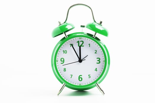 Picture of a green retro alarm clock on a white background with the clock five to twelve