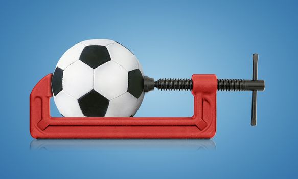 horizontal hand vise c-clamp and football, sport conceptual image