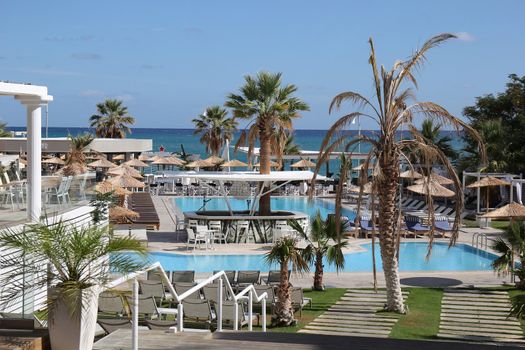 landscape with beach umbrellas and deck chairs on the background of sea and sky