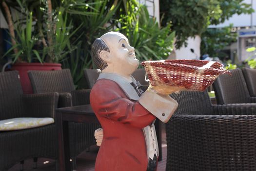 waiter in a red jacket with wicker basket
