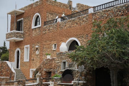 ancient Greek house with a stone staircase and balcony