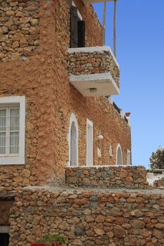 ancient Greek house with a stone staircase and balcony