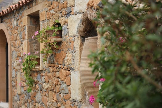 Greek village house with a tiled roof and flowers
