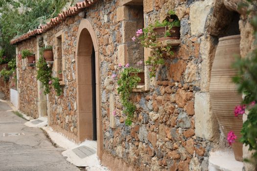 Greek village house with a tiled roof and flowers
