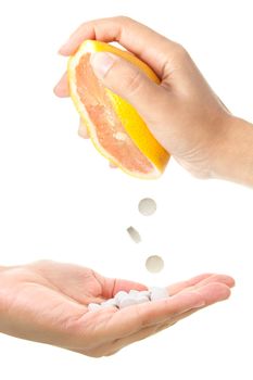 Conceptual image of vitamin tablets being squeezed out of a grapefruit