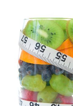 Five fruits packed into a glass including kiwi, berries and orange 