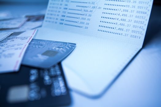 Balance of savings deposit passbook, sale slip and credit card, Blue toned, shallow DOF