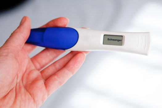 Woman taking a pregnancy test showing pregnant result