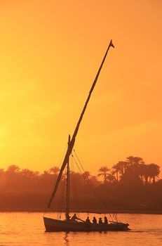 Felucca boat sailing on the Nile river at sunset, Luxor, Egypt