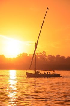 Felucca boat sailing on the Nile river at sunset, Luxor, Egypt